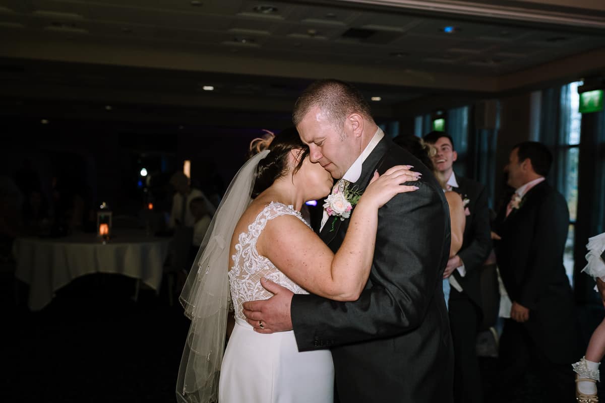 Bride and groom embracing during their first dance in the Cavendish Suite at Abbey House Hotel, Barrow-in-Furness