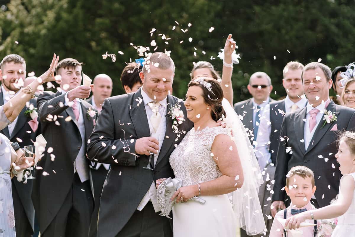 Bride and groom and confetti on the grounds of Abbey House Hotel