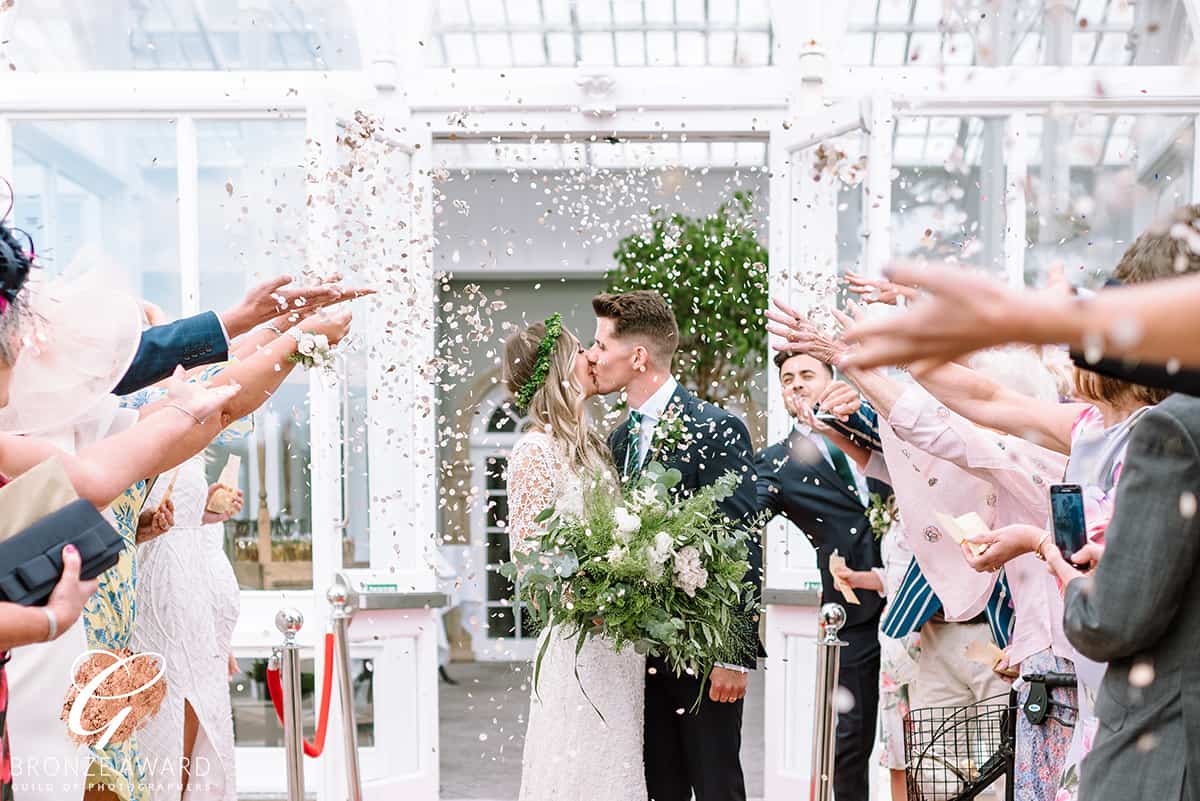 Bride and Groom kissing a the Hilton Hotel Chester while confetti is being thrown