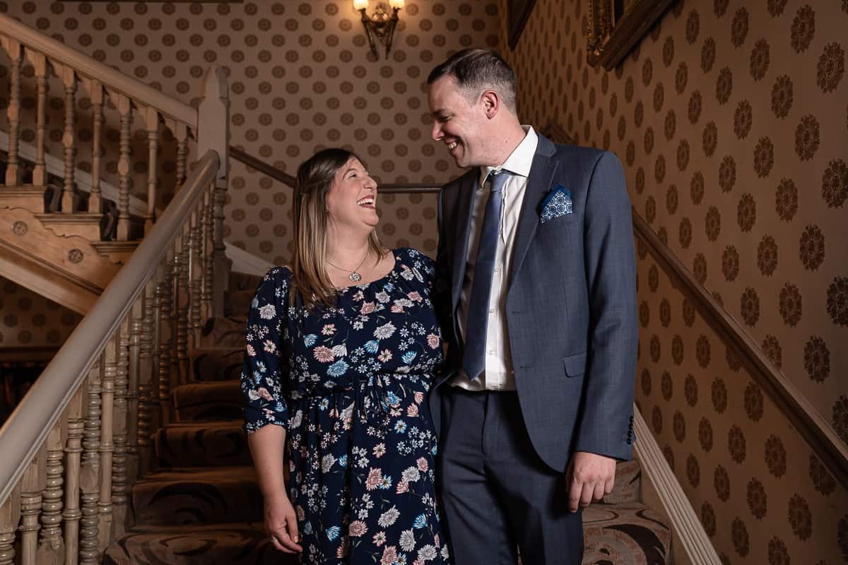 Smiling, happy couple on the staircase at the Grosvenor Hotel, Chester, Cheshire